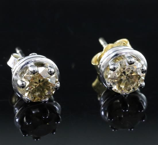 A pair of fancy yellow diamond and 18ct white gold ear studs, (the brilliant-cut diamonds approximately 1.0ct each).